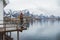 Young man with a backpack standing on a wooden pier the background of snowy mountains and lake. Place for text or advertising