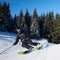 Young man backpacker skiing up and down slopes. Male skier training in sunny winter day. Backcountry skiing concept.