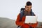 Young man backpacker using his laptop in mountain journey