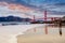 Young man on Baker Beach and a magnificent view of the Golden Gate Bridge at dawn