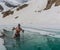 Young man bathing in the ice hole