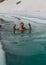 Young man bathing in the ice hole