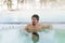 Young man in bathtub jacuzzi outdoors at winter