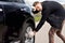 Young man battling to change the tyre on his car