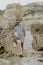 Young man on the beach, man walking on the rocky beach coastline