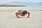 Young man on the beach, young muscular man exercising on the beach, young muscular man doing bodibuilding exercises on the beach,