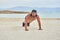 Young man on the beach, young muscular man exercising on the beach, young muscular man doing bodibuilding exercises on the beach,