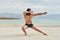 Young man on the beach, young muscular man exercising on the beach, young muscular man doing bodibuilding exercises on the beach,