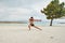 Young man on the beach, young muscular man exercising on the beach, young muscular man doing bodibuilding exercises on the beach,