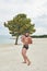 Young man on the beach, young muscular man exercising on the beach, young muscular man doing bodibuilding exercises on the beach,