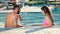 Young man with beard and beautiful woman relaxing in the swimming pool