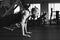 A young man with a beard does a push-up exercise in the gym. Black and white photography