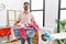 Young man with beard holding laundry basket angry and mad screaming frustrated and furious, shouting with anger looking up