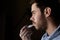 Young man with a beard repairing his damaged lips with moisturizer