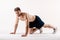 young man with a beard of a sports physique doing push-ups from the floor on a white isolated background, sportsman goes