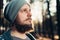 A young man with a beard walks in a pine forest. Portrait of a brutal bearded man Autumn forest