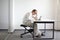 Young man is bent over his tablet.Bad sitting posture at work