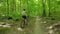 Young man in a bicycle helmet rides a bicycle through the forest. Following Shot