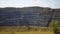 A young man on a bicycle rides along the cliff of the canyon, stops at the edge, looks around and goes farther