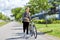 Young man with bicycle walking along city street