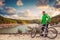 Young man with bike enjoy with beautiful mountain lake view