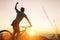 Young Man biker man meets a sunset in top of hill. He rising a one arm greeting on another successful day ending. Active sport