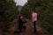 Young man in black coat kneels in front of beautiful woman, proposes marriage in forest