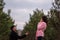 Young man in black coat kneels in front of beautiful woman, proposes marriage in forest
