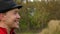 Young man in a black hat stands in a forest, shows a thumb up gesture in slo-mo