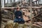 Young man in black kimono with a sword meditates and concentrates on rocks and forest background. Place for text or advertising