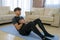 Young man with black sportswear practicing exercise in the living room at home