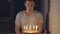 Young man blows out candles on a festive cake