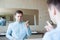 A young man in a blue shirt adjusts his hair in front of the mirror in the toilet. He worries and prepares for meeting