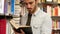 Young man in bookstore or library leafing through book