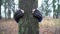 Young man in boxing gloves is hugging tree in forest and loving nature. Hands of adult caucasian male environmental