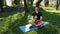 Young Man Breathing Deep With A Green Forest In The Background. Practice Yoga In The Park On A Rug That Lies On The