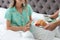 Young man bringing romantic breakfast to his girlfriend in bed at home