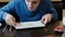 Young man brunette in blue sweater eats the crumbs from the plate and licks the plate with tongue.