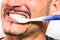 Young Man brushing white perfect Teeth with a Toothbrush