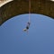 Young man bungee jumper hanging on a cord