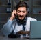 Young man in call center concept working late overtime in office