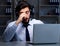 Young man in call center concept working late overtime in office