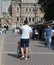 Young man caregiver pushing wheelchair with female person with disability across city street