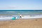 Young man carrying his kayak along the shore