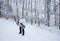 Young man carrying his snowboard back uphill