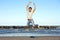 Young man in casual wear leaping in air at beach