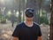 Young man with a cat-shaped mask celebrating Halloween in a forest