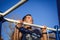 A young man of Caucasian appearance pulls himself up on a horizontal bar.