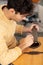 young man changing guitar strings at home