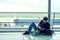 Young man checking his phone while waiting his flight in the air